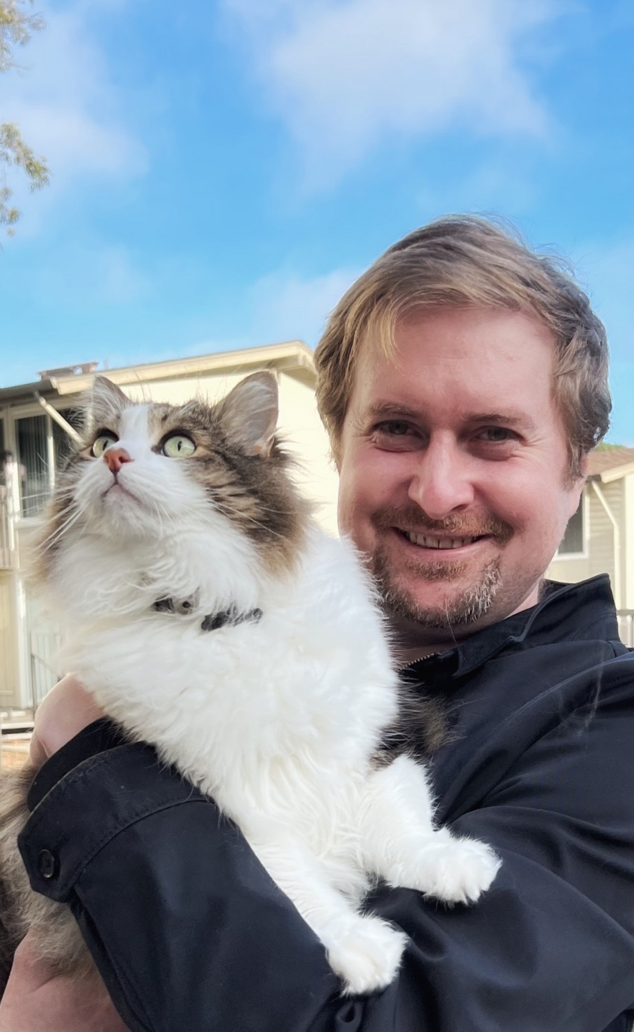 Erik Holding a White and Grey Cat